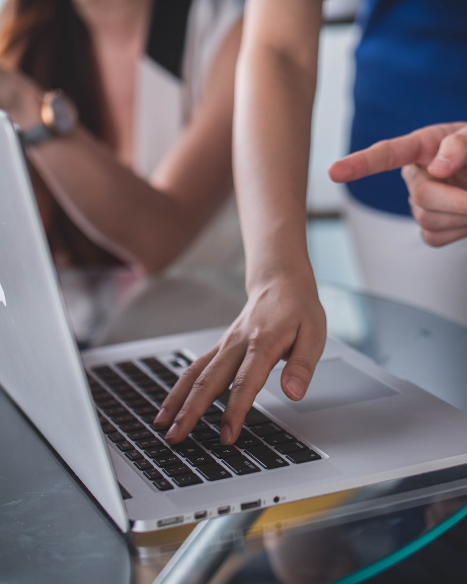 Two people reviewing figures on a laptop screen